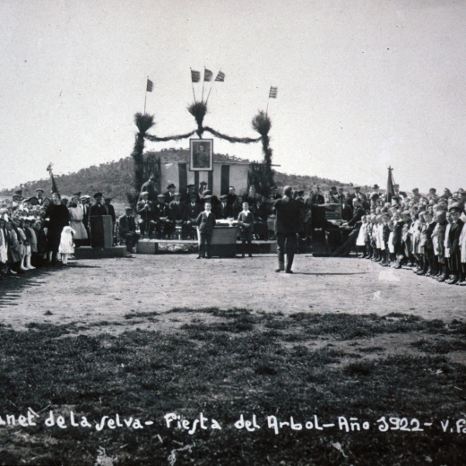 Festa de l'arbre l'any 1922 celebrada en els terrenys on es van construïr els nous col·legis que s'insguraven el proper anys 1923. Davant de la tribuna presidencial es pot observar el Turó d'en Roura. Com a detall significatiu observem com a sobre l'imprescindible retrat del Rei, llavors Alfons XIII hi ondegen senyeres catalanes. Fou per poc temps ja que aviat s'esevingué el cop d'estat de Primo de Rivera que portà una ferotge persecussió de tot símbol de Catalunya.