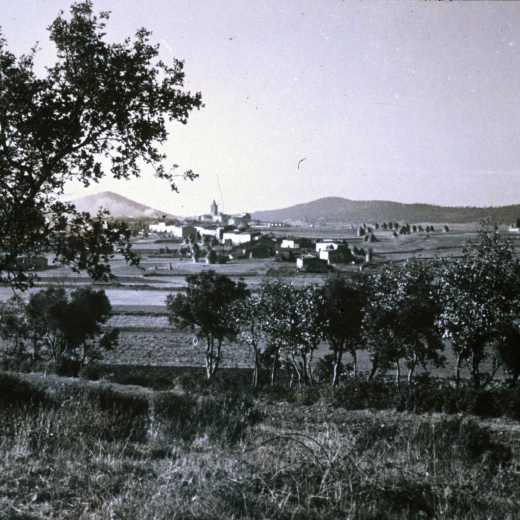 Vista parcial de la vila de Maçant des del turó d'en Dot molt temps abns de començar l'expansió urbanística del poble. Es pob observar el gran nombre de pallers que es feien tant al darrera de les cases com a l'era d'en Júria i a l'anomenada 