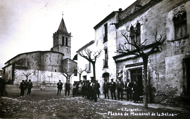 Vista de la plaça de l'Església l'any 1918. En primer plà Ca l'Orench i Can Júria un diumenge al mig dia.