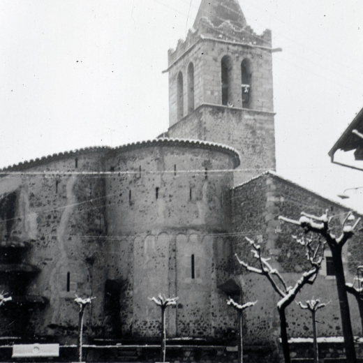 La plaça i el campanar sota una petita nevada.