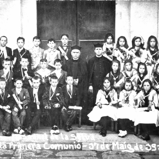 Les noies i els nois de la comunió solemne el 17 de maig de 1917 amb el rector Mn Joan Vicens i el vicari Mn Roura a l'entrada de l'Església Parroquial