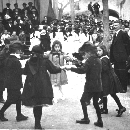 Festa de l'arbre de l'any 1918 a Maçanet. El mestre Sr. Pere Cantenys observa atentament la ballada d'una sardana antiga. Els balladors són: Leocàdia Casabó, Enriqueta Ruscalleda, Maria Guinart i Nativitat Llirinós; i els nois: Alfons Surís, Joan Fàbregas, Marc Casabó i Josep Bosch