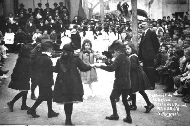 Festa de l'arbre de l'any 1918 a Maçanet. El mestre Sr. Pere Cantenys observa atentament la ballada d'una sardana antiga. Els balladors són: Leocàdia Casabó, Enriqueta Ruscalleda, Maria Guinart i Nativitat Llirinós; i els nois: Alfons Surís, Joan Fàbregas, Marc Casabó i Josep Bosch