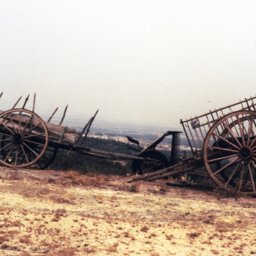 Detall d'una carreta, un carro i una màquina de segar oserda.