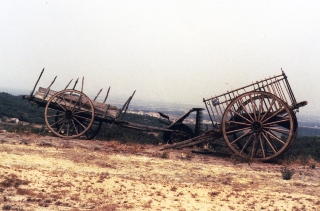 Detall d'una carreta, un carro i una màquina de segar oserda.
