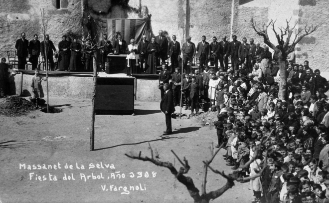 Festa de l'arbre l'any 1918 a la plaça de l'Església. Moment en que dos nois sostenen dos arbres en el moment de la seva plantació