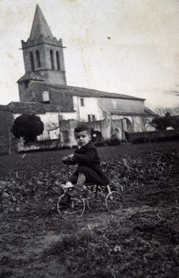 El petit Joan Selva passejant amb un tricicle prop de casa seva