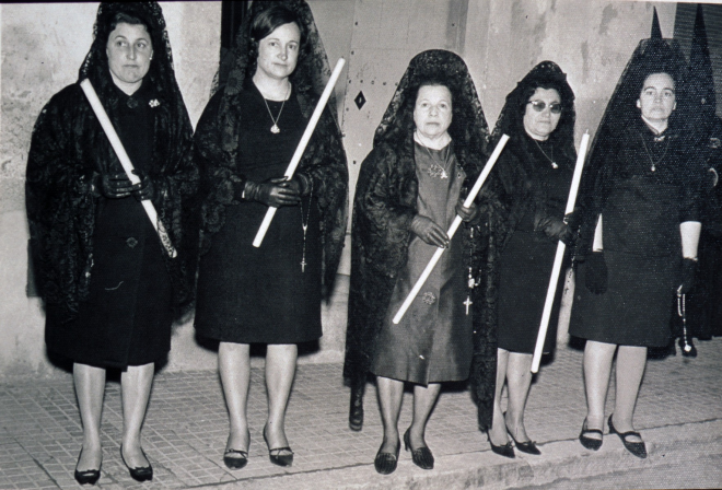 Un grup de senyores acompanyants de la Mare de Déu dels Dolors en la processó del Divendres Sant.

D'esquerra a dreta: Isabel Pi, Emilia Nadal, Felicitat Llirinós, Angela Reyner, i Herminia Riera.