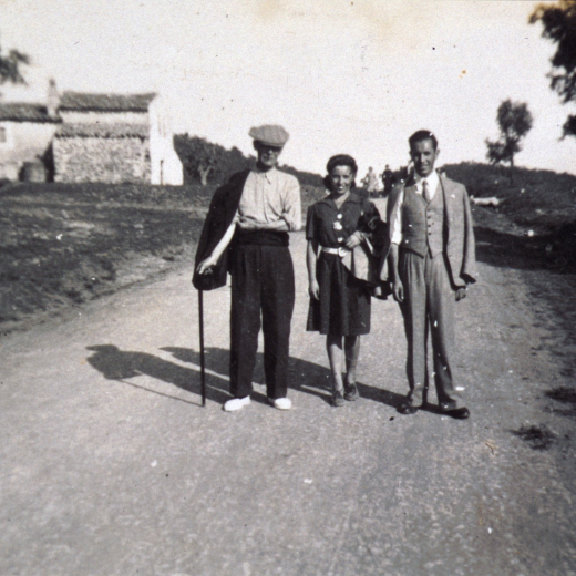 En Josep Orench i Turbany amb els seus fills Assumpció i Antoni Orench Clos, passant per la carretera camí de Martorell. Al fons es veu la casa Cal Rei de la Cendra, que avui és desapareguda.