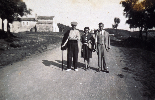En Josep Orench i Turbany amb els seus fills Assumpció i Antoni Orench Clos, passant per la carretera camí de Martorell. Al fons es veu la casa Cal Rei de la Cendra, que avui és desapareguda.