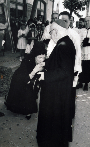 Visita pastoral a Maçanet del Bisbe de Girona Sr. Cartañà. La padrina de confirmació és la Sra. Dolors Llach junt amb el padrí el Sr. Àngel Marsà donant la benvinguda al Sr. Bisbe en presència del Sr. rector Mn Francesc Berga.