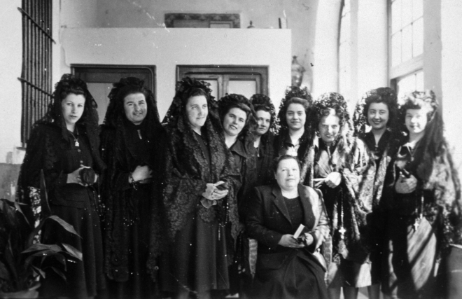 Un grup de dones acompanyants de la Verge dels Dolors en la processó del Divendres Sant. Entre elles hi podem reconèixer a Maria Bancells, Dolors Deulofeu, Maria Ciurana, Carme Negre, Joaquima Orench, Pilar Tomàs i Maria Bosch. A davant asseguda hi ha la Felicitat Llirinós.