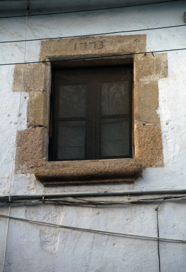 Una finestra de pedra de l'any 1773 a la casa Can Buscastells, abans d'esser enderrocada i edificada novament.