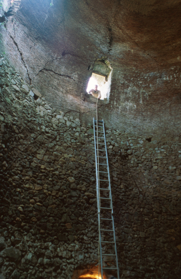 Interior del pou del glaç de Can Buscastell amb l'escala de mà posada i en Martí Tomàs a punt per baixar-hi