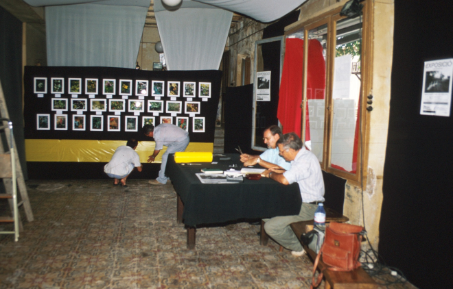 La gent del Taller d'història muntant l'exposició de fotografies que tradicionalment es mostra cada any per la Festa Major.