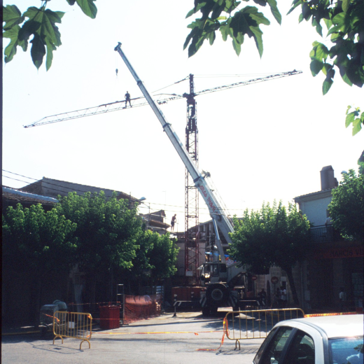 Treballs d'instal·lació d'una grua per efectuar treballs de restauració a Ca l'Orench a la plaça de l'Eglésia.