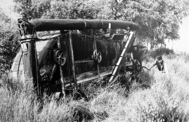 Una antiga màquina de batre de marca americana, abandonada per desús.