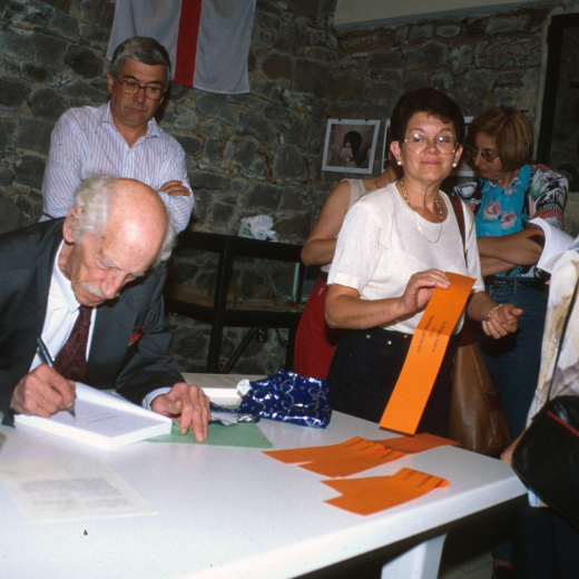 El Sr. Manel Anglada signant uns papers en presència de Juli Campeny, Assumpció Artigas i Susana Clarió