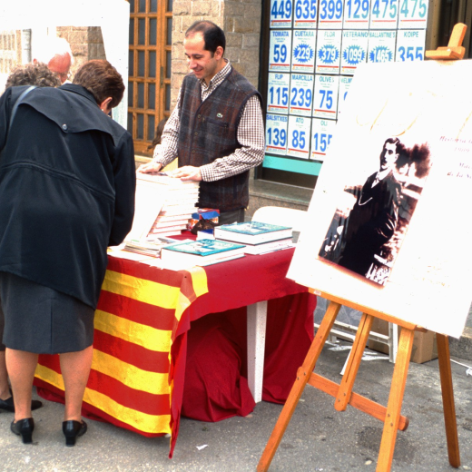 En Josep Costa en el lloc de venda de llibres del taller d'Història, el dia de la Fira artesanal de Maçanet.