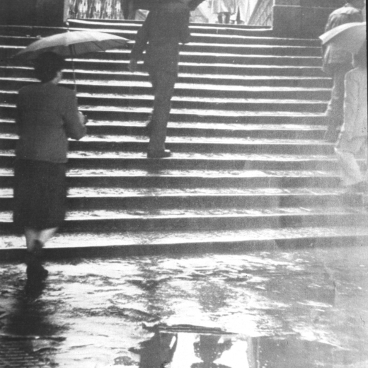 Un dia de pluja a Girona al peu d'un pont que travessa el riu Onyar.