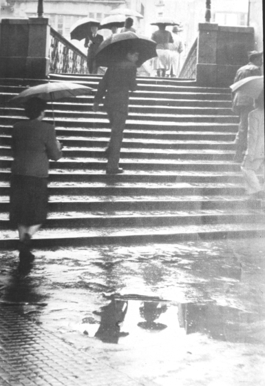 Un dia de pluja a Girona al peu d'un pont que travessa el riu Onyar.