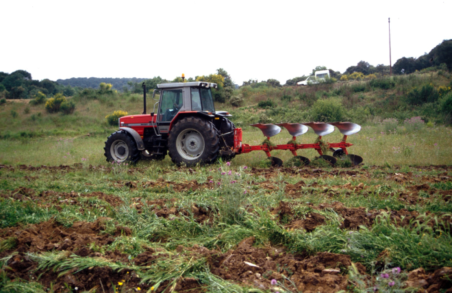 Un tractor llaurant un camp
