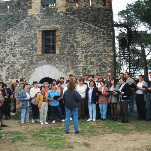 La coral El Gínjol acabada la missa, canten Els Segadors mentre és aixecada la Senyera a dalt de la Capella la que presideix permanentment el complex del castell de Torcafelló
