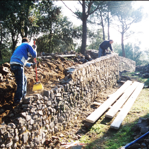El paleta Joan Machado i el seu ajudant en els treballs de reconstrucció dels murs del fossar del castell de Torcafelló