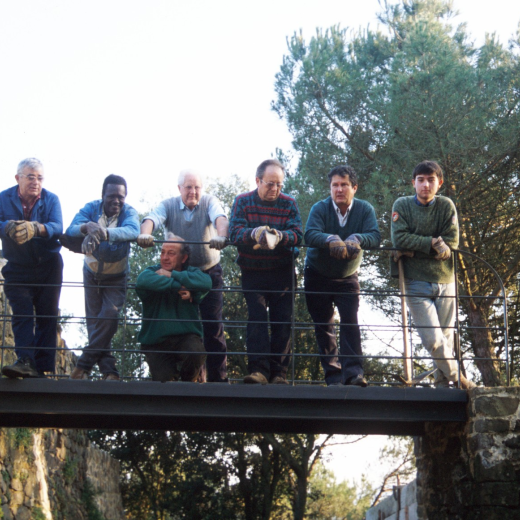 Integrants del grup de treball del taller d'història a Sant Jordi, dalt del pont d'accés a la fortalesa. D'esquerra a dreta: Xavier Vergés, un noi de color ajudant del paleta Joan Machado que està ajupit. En Martí Tomàs, en Josep Panosa, en Josep Soler i en Jordi Vergés. En Juli Campeny tirava la foto