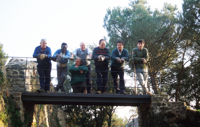 Integrants del grup de treball del taller d'història a Sant Jordi, dalt del pont d'accés a la fortalesa. D'esquerra a dreta: Xavier Vergés, un noi de color ajudant del paleta Joan Machado que està ajupit. En Martí Tomàs, en Josep Panosa, en Josep Soler i en Jordi Vergés. En Juli Campeny tirava la foto
