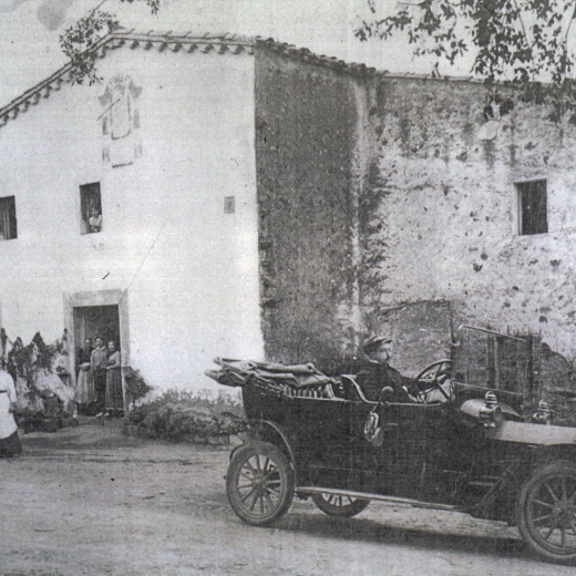 Vista de l'hostal de Cal Coix i en primer terme un cotxe de l'època