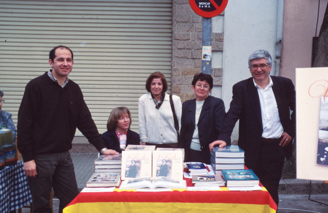 Parada de venda de llibres del taller d'història a la fira artesanal.

D'esquerra a dreta: Josep Costa, asseguda Glòria Caballer, Angela Artigas, Assumpció Artigas, i el Cap de Colla i President de l'entitat Juli Campeny. Estan molt contents perquè fa bon temps i la venda va bé.