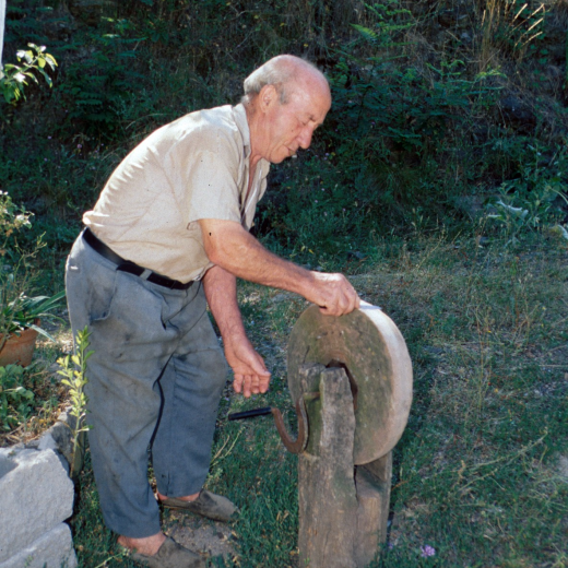 En Josep M Ciurana de Can Dalemus esmolant amb una rudimentària mola manual tal com es feia molts anys enrera.