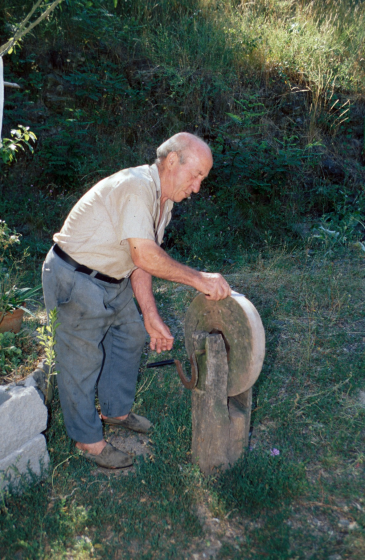 En Josep M Ciurana de Can Dalemus esmolant amb una rudimentària mola manual tal com es feia molts anys enrera.