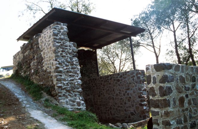 Els murs dels fossars de Torcafelló ja recontruíts i una vista de l'antiga cisterna de la fortalesa
