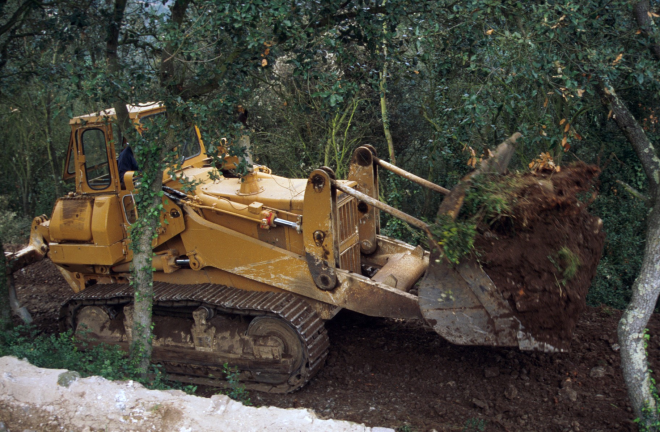 La màquina excavadora treballant en l'obertura del camí que envoltarà tot el recinte de Sant Jordi