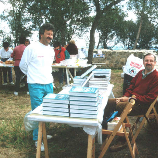 Mentre les dones col·laboradores preparen diligentment el dinar per l'aplec, en Manel Maestre i en Lluís Soler atenen la venda de llibres del taller d'Història.