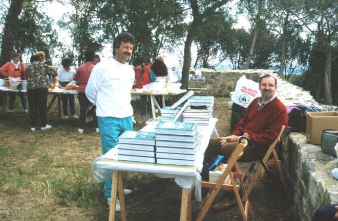Mentre les dones col·laboradores preparen diligentment el dinar per l'aplec, en Manel Maestre i en Lluís Soler atenen la venda de llibres del taller d'Història.