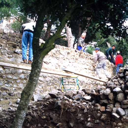 Reconstrucció dels murs dels fossars de Sant Jordi. Ajudant als paletes hi ha en Xavier Vergés i en Josep Soler.