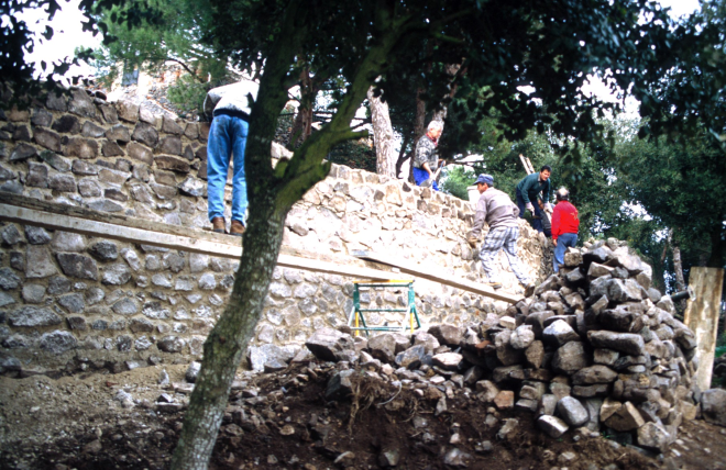 Reconstrucció dels murs dels fossars de Sant Jordi. Ajudant als paletes hi ha en Xavier Vergés i en Josep Soler.