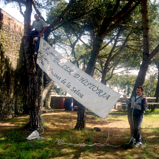 En Josep Costa i en Simó Serra col·locant la pancarta del Taller d'història a Sant Jordi