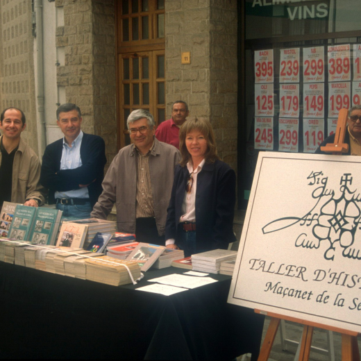 En Josep Costa, Lluís Planas, Juli Campeny i Glòria Caballé en la parada del Taller d'història a la Fira del Roser el maig del 99