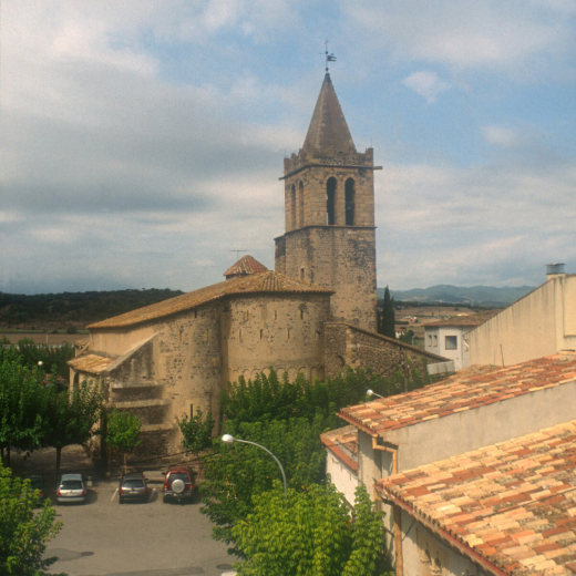 Vista de la plaça amb el campanar i l'absis de l'església parroquial.