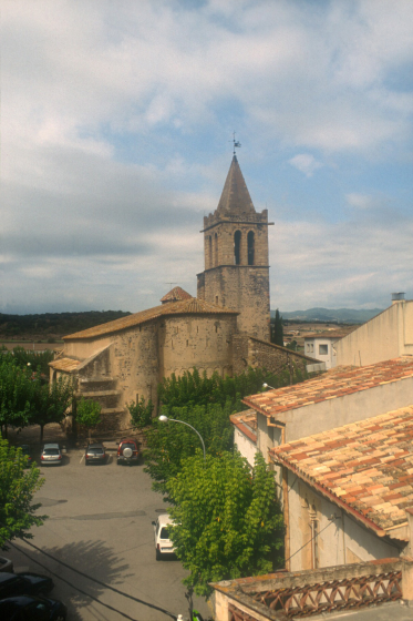 Vista de la plaça amb el campanar i l'absis de l'església parroquial.