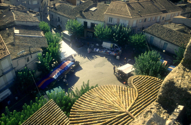 Una foto de la plaça de l'església vista des de dalt del campanar en un dia de mercat a l'estiu.