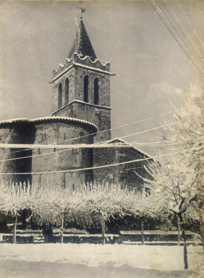 Detall de la plaça i campanar de Maçanet, amb una d'aquelles nevades que molt freqüentment queien en els hiverns d'anys enrera.