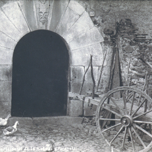 Portal d'entrada de Can Reixach amb una colla d'ànecs i la carreta