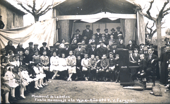 Festa d'homenatge a la vellesa a la plaça de l'Església l'any 1918. 

La presidència amb les autoritats i el pianista Sr. Rosendo Riba. L'escenari estava situat davant de la casa llavors anomenada Can Roig i davant l'entrada de l'Església.