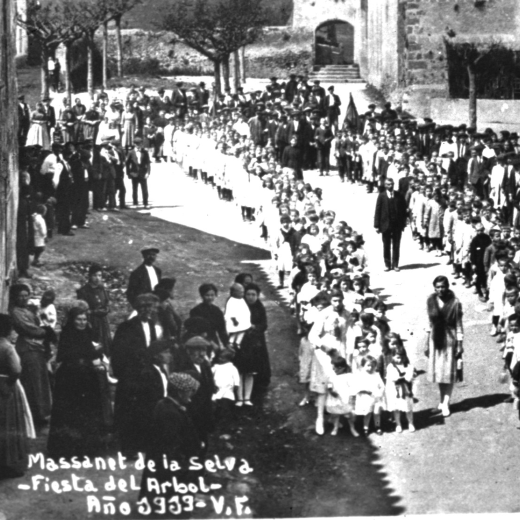 Festa de l'arbre l'any 1919 amb els alumnes de les escoles i els mestres a la sortida de l'Església. Al fons de la fotografia es poden observar l'antic porxet i la pared que tancava l'hort de la rectoria, avui tot desaparegut.