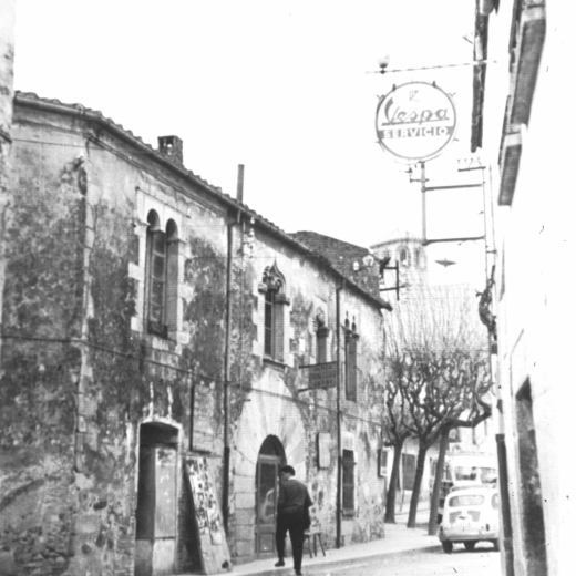 Detall del casal del cavaller a la plaça de l'Església abans de la seva restauració els anys 70.

Es pot observar la pissarra amb l'anunci de les pel·lícules que es progectaran a la Societat i els quadrets de propaganda.

El portal rodó era l'entrada de la que fou, durant molts anys, la carnisseria Can Jordi.